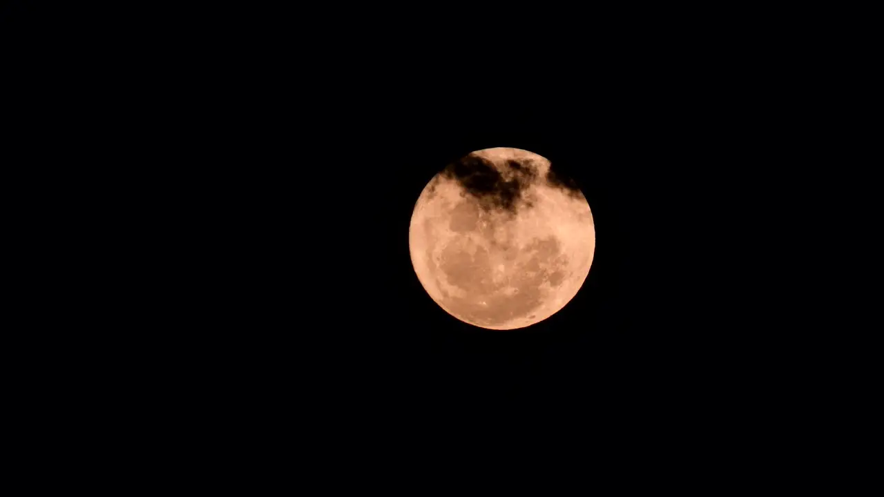 Full moon with clouds passing by 