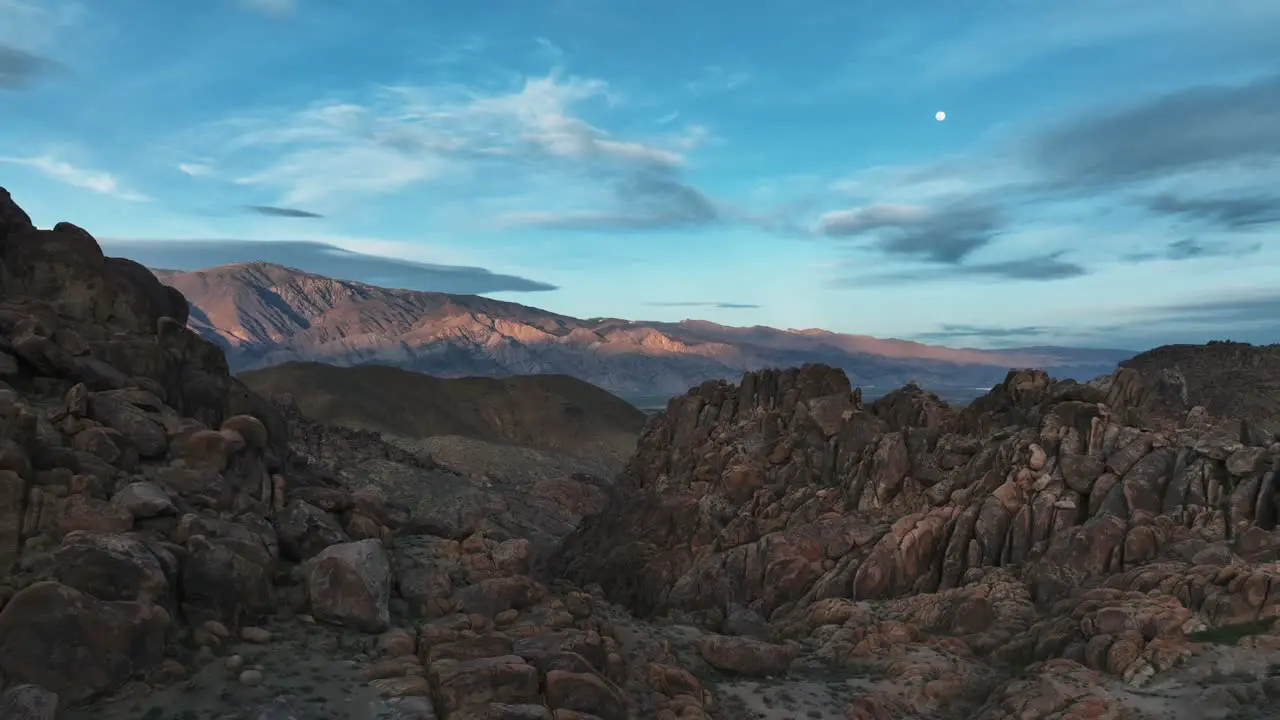 Sunset with a moon over the rocks of the iconic Alabama Hills