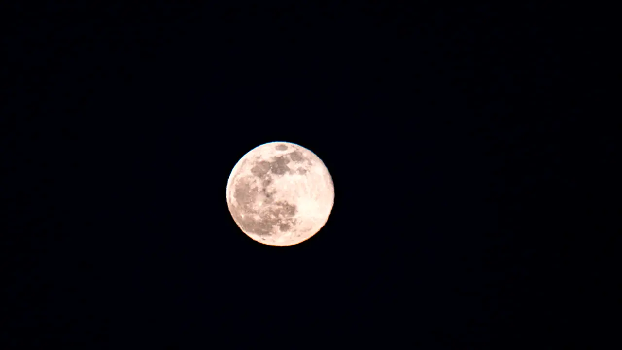 Time lapse of the full moon moving up and the the right through frame