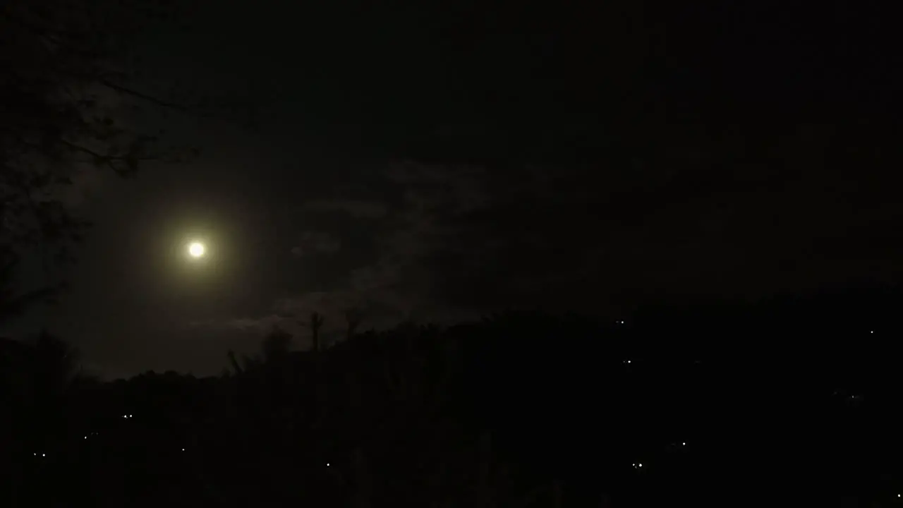 Clouds drift across dark sky in black night moon rise time lapse