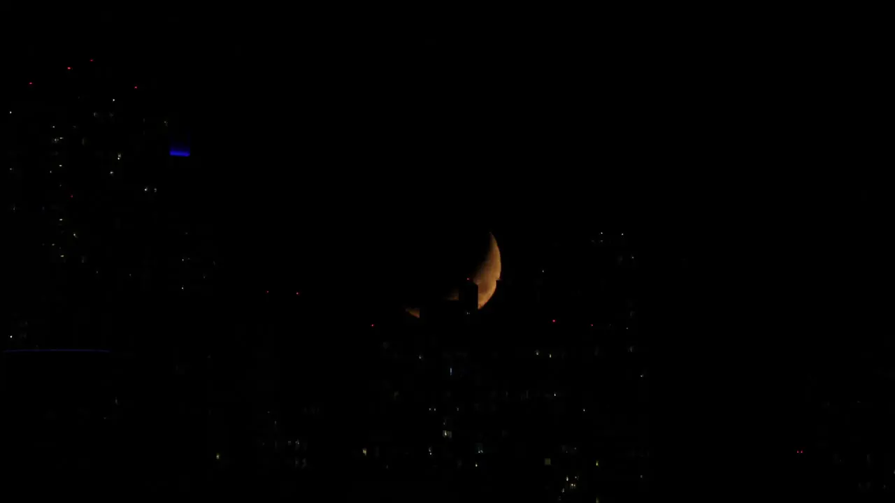 Urban half moon time lapse hiding behind buildings