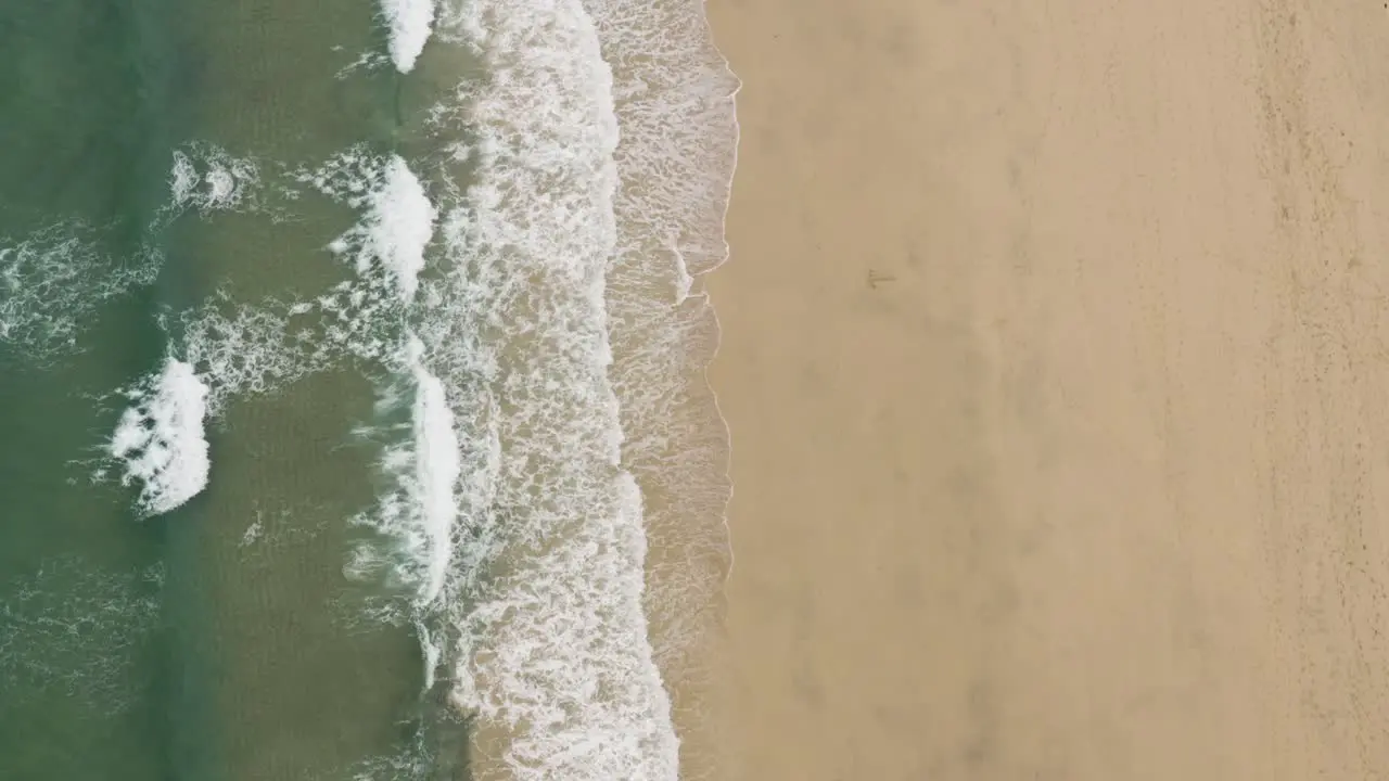 Vertical Shot Of Foamy Waves Washed Over Sandy Shore At St Ives Cornwall England