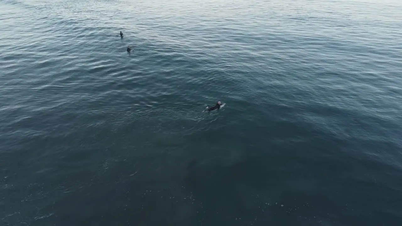 A beautiful aerial drone shot of a man supping in the ocean close to the beach Carlsbad State Beach California