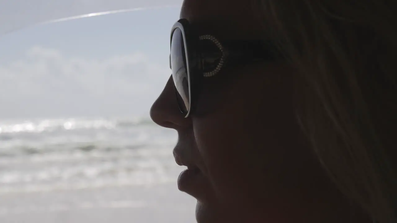 Young female adult removing sunglasses driving road trip