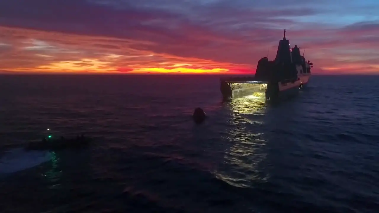 Aerial Drone Footage Of A Large Military Boat With Its Hatch Open About To Receive A Test Re Entry Spacecraft Sunset 2019