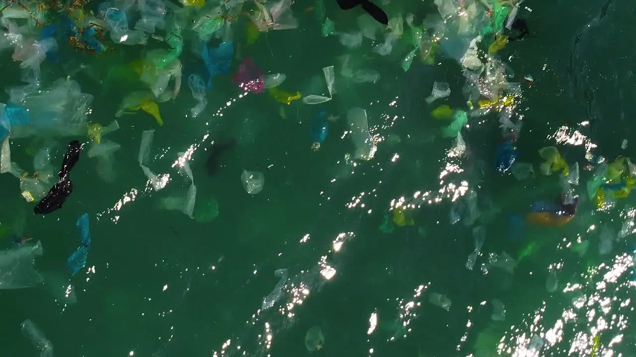 Floating plastic rubbish on blue tropical ocean top down view