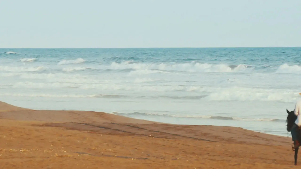 Hispanic man with straw hat riding horse on Guatemala beach SLOW MOTION