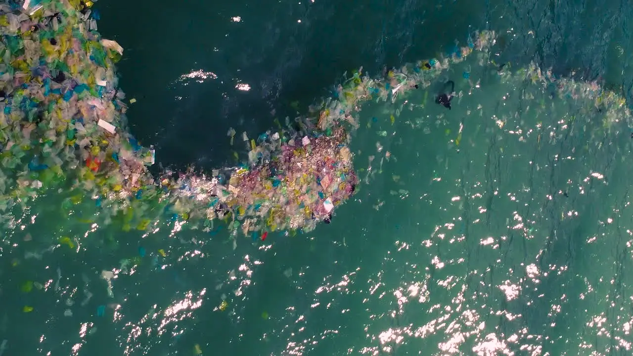 Vertical shot of plastic bags and rubbish floating in sea waters