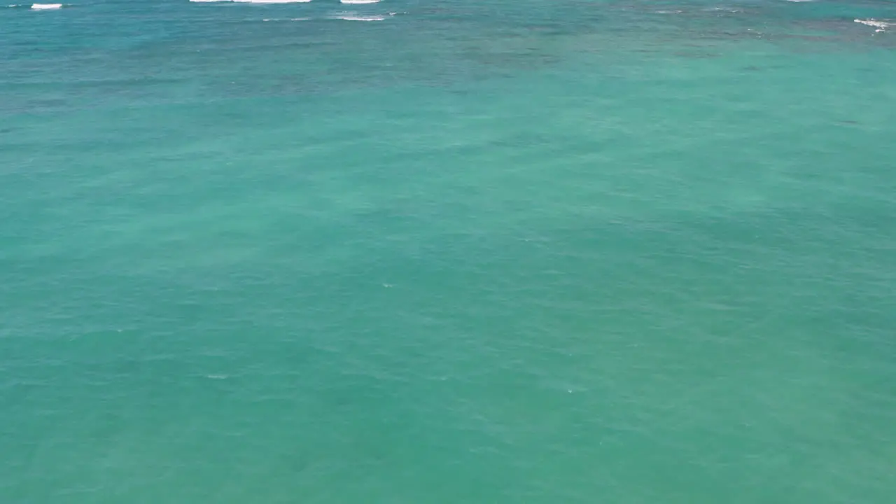 Aerial drone shot over deep blue ocean along Hawaii coastline