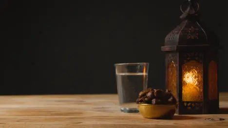 Tracking Shot of Lantern Water and Dates On a Table for Ramadan