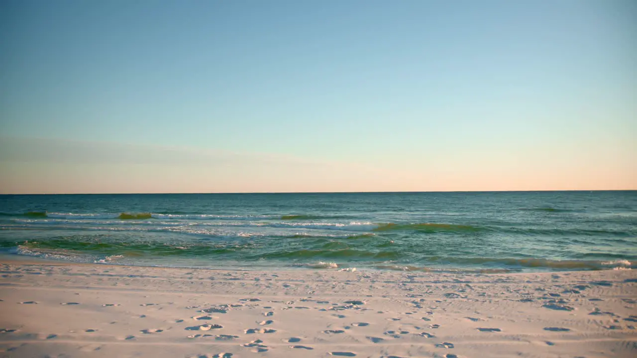 Shots of the ocean on a warm sunny evening with footprints in the sand-1