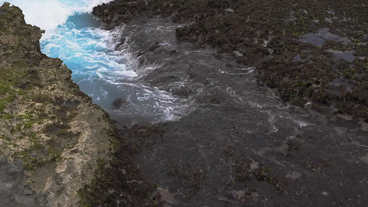 Waves crashing on the rocky reef in slow-motion creating a beautiful foam pattern during the day