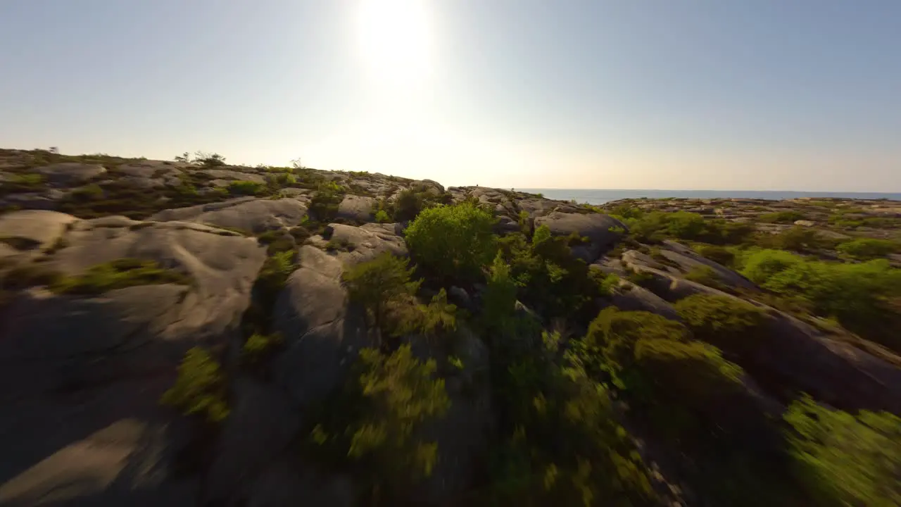 FPV drone flying low over treetops and cliffs in Ramsvik Sweden