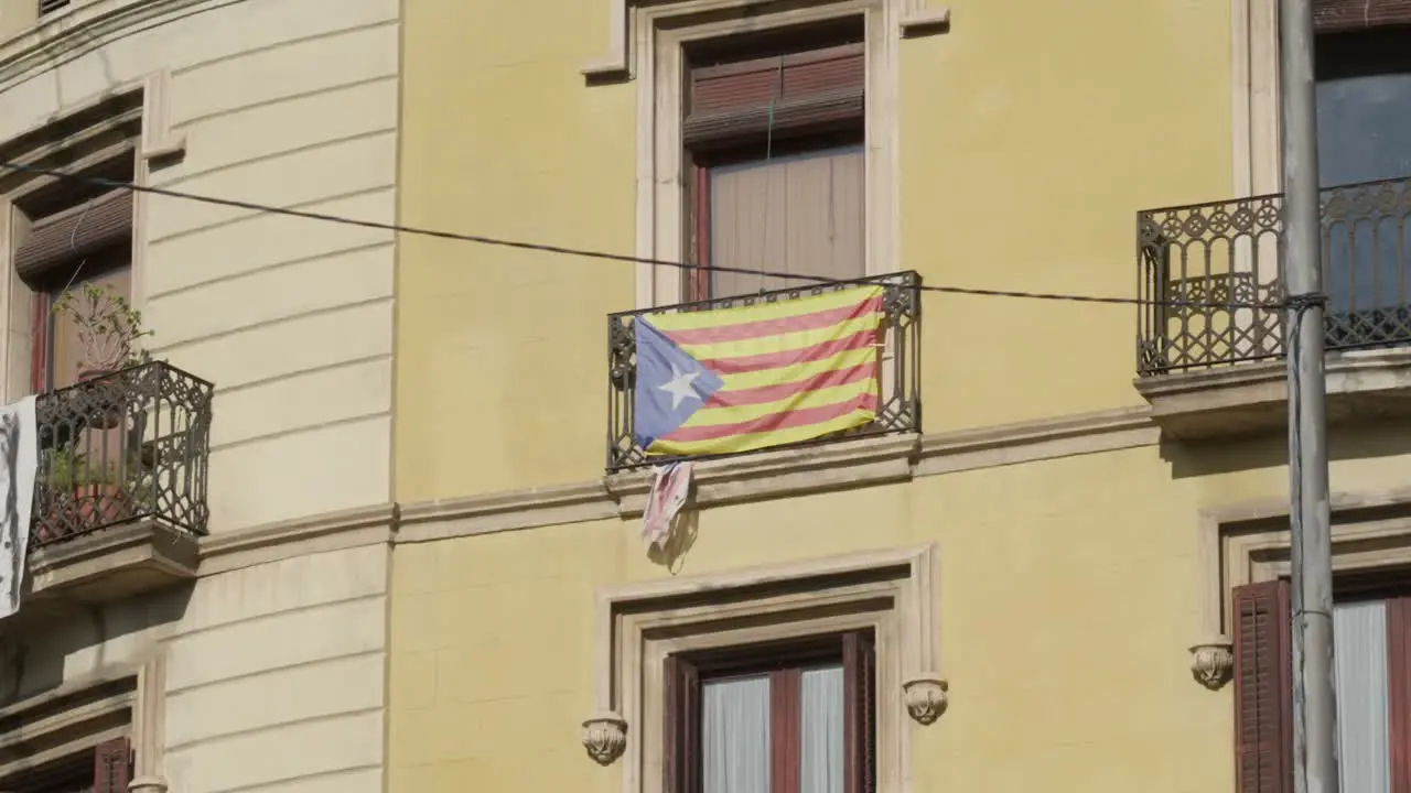 Catalonia flag raised on building balcony in Barcelona city handheld