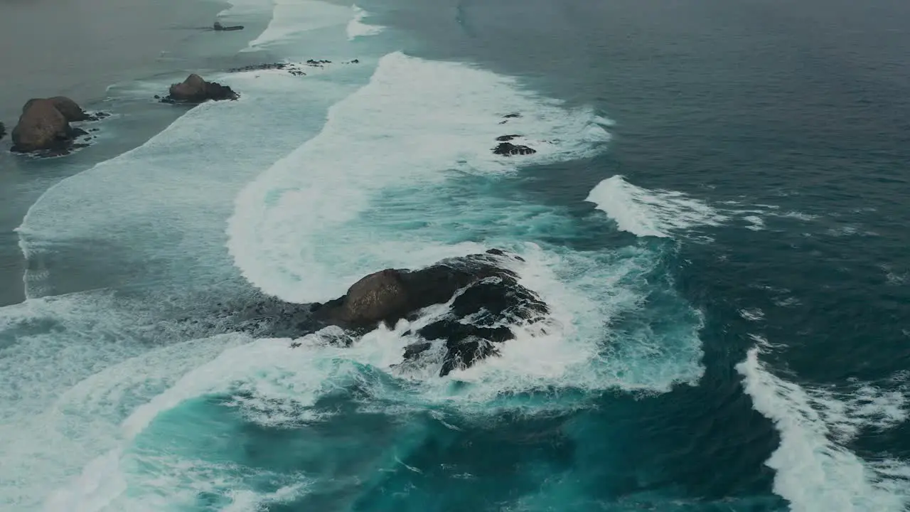 Aerial of rocky Gili Angkus at coast of Lombok with crashing waves