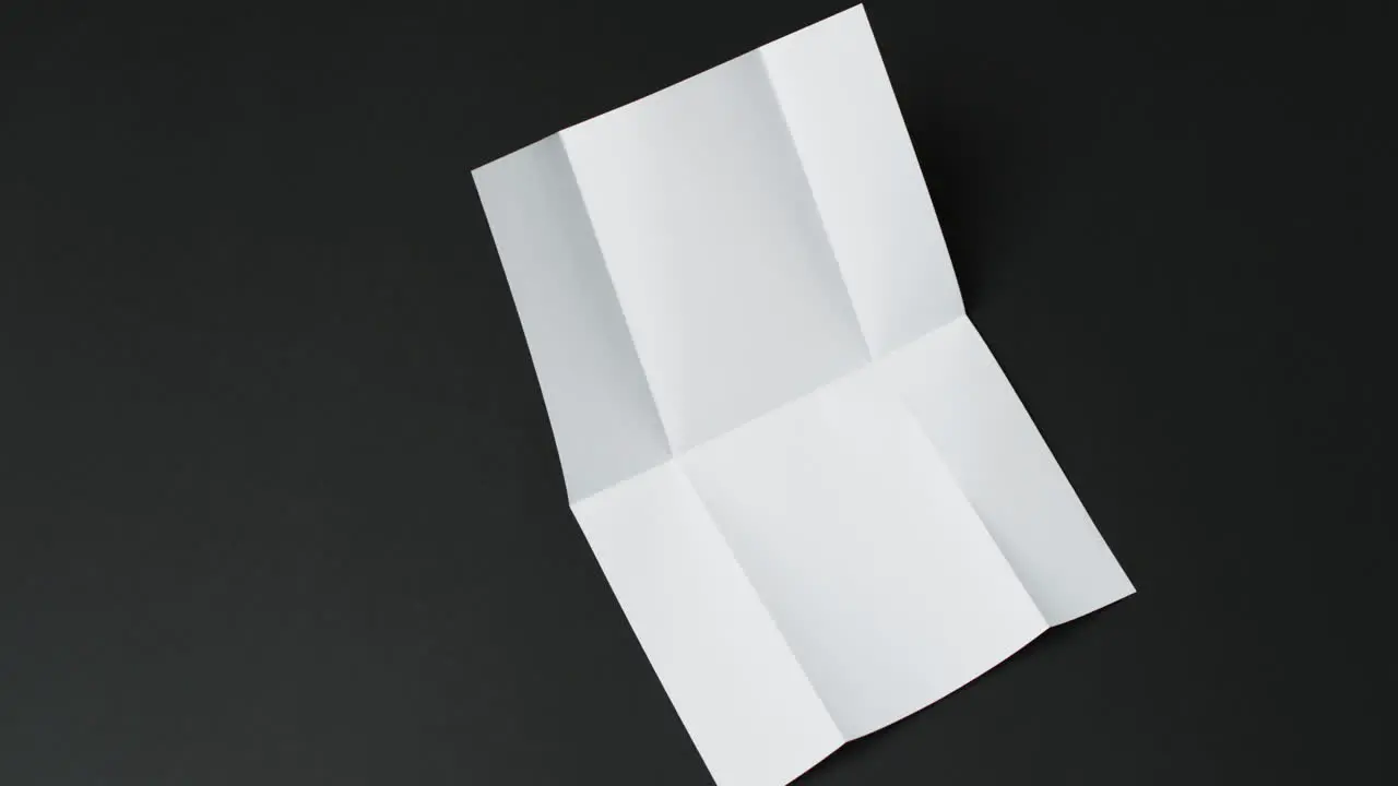 Video of piece of white paper with creases on black background