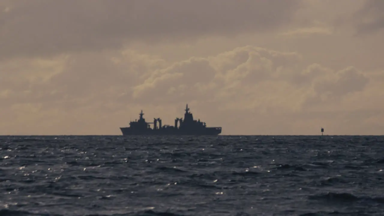 Navy warship patrolling the coastline on a cold cloudy dull day