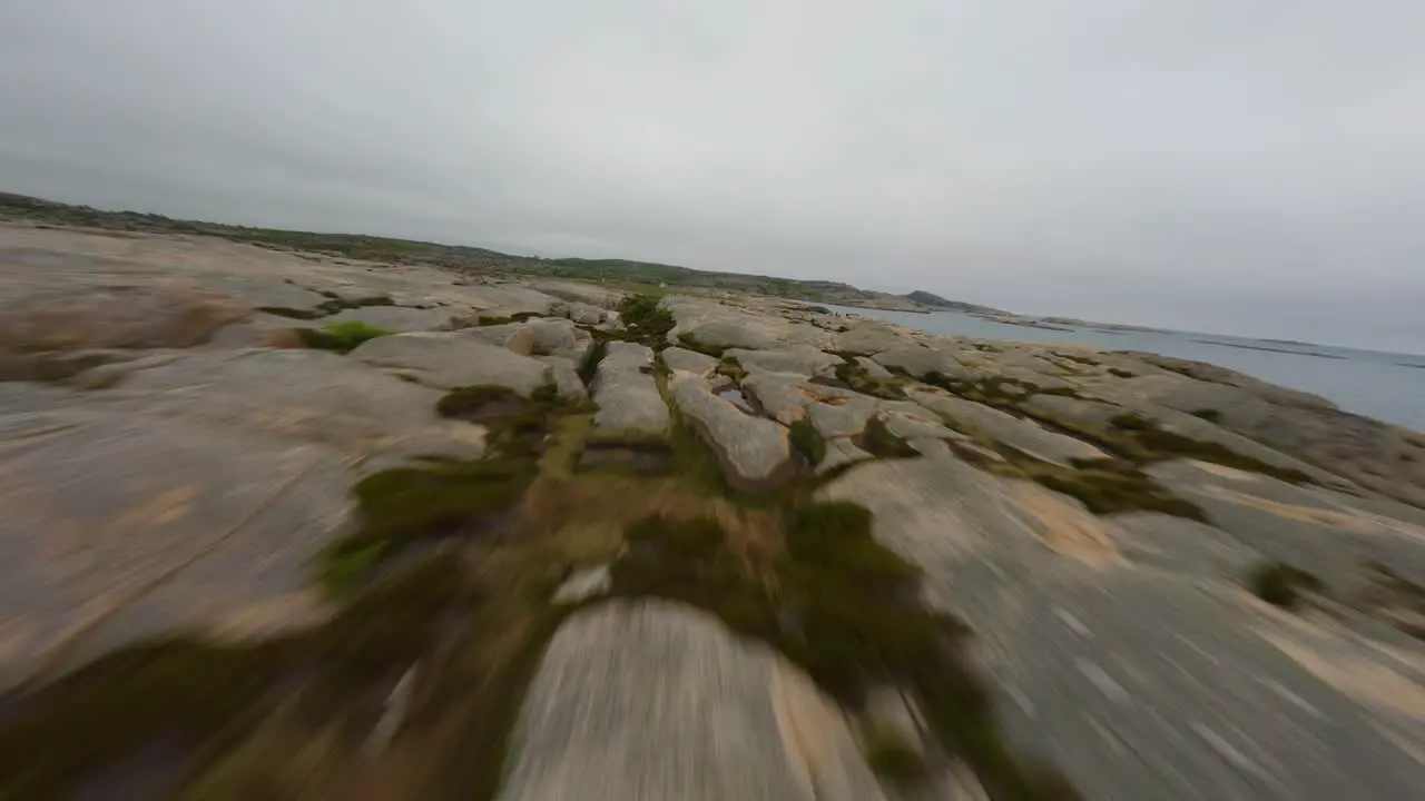 Low flight over red rock terrain of Ramsvik coast in Sweden