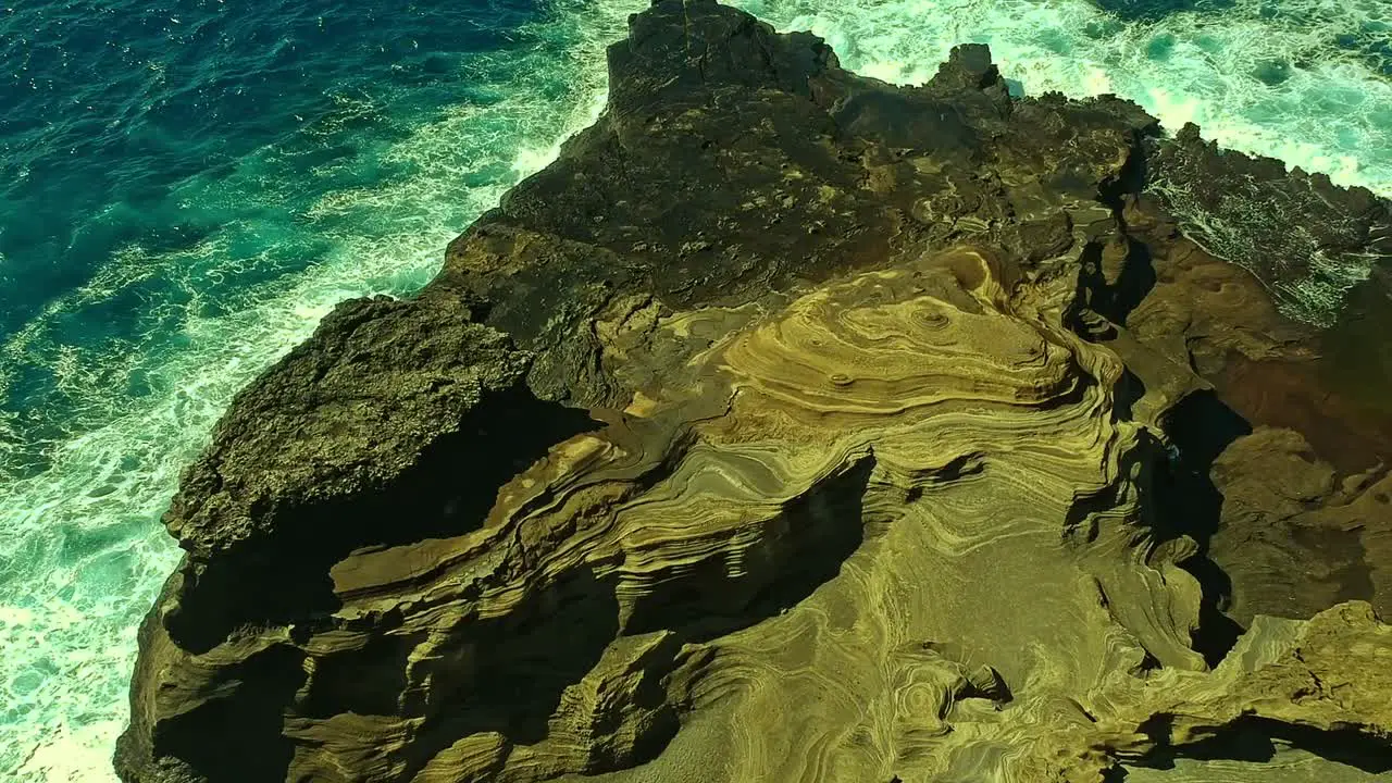 Overhead view of waves splashing over volcanic rock formation on Oahu