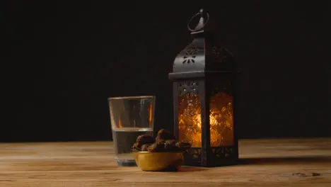 Tracking Shot of Dates Water and a Lantern On a Table