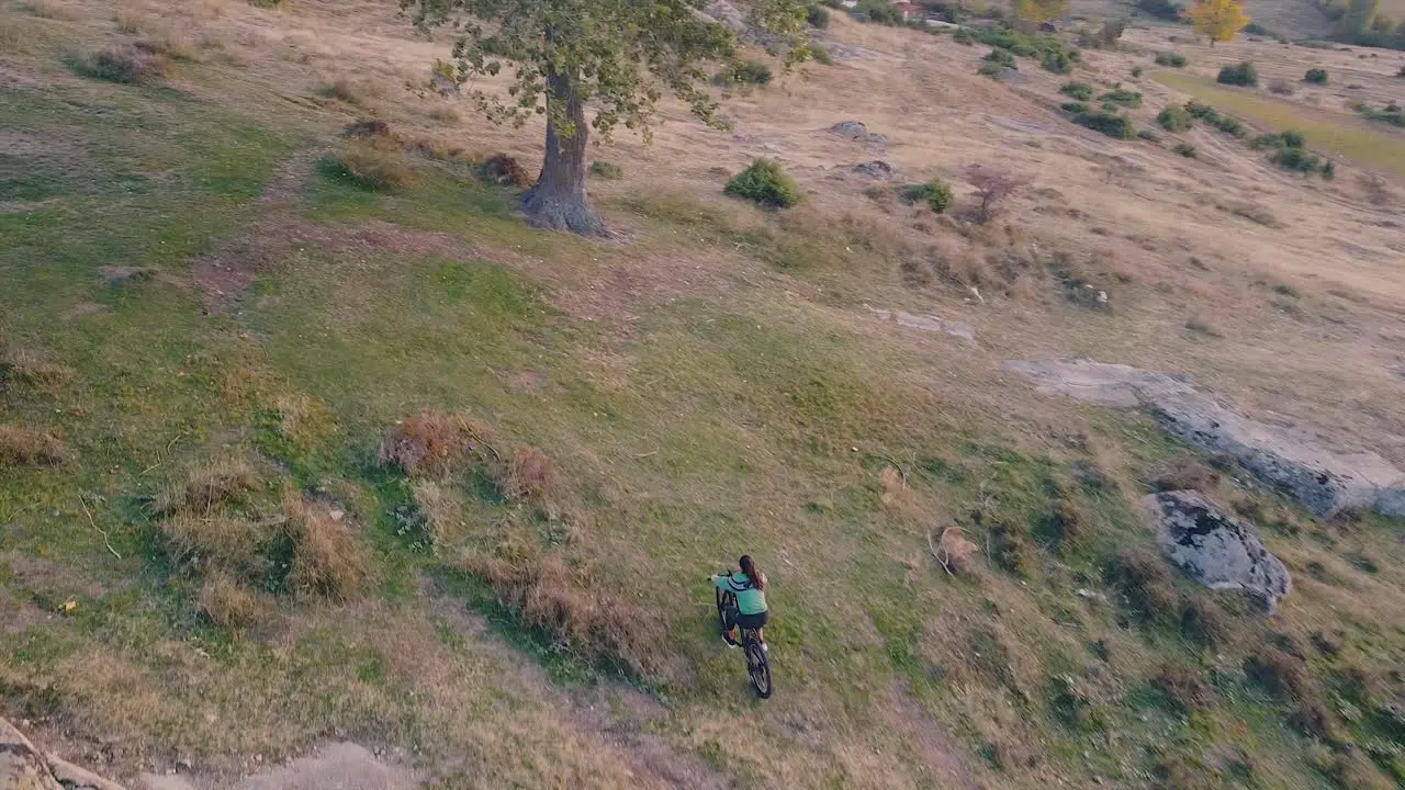 Girl riding a bike in nature drone shot