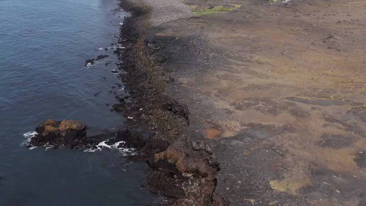 Wild coast of Iceland with solid lava field with water from Atlantic Ocean