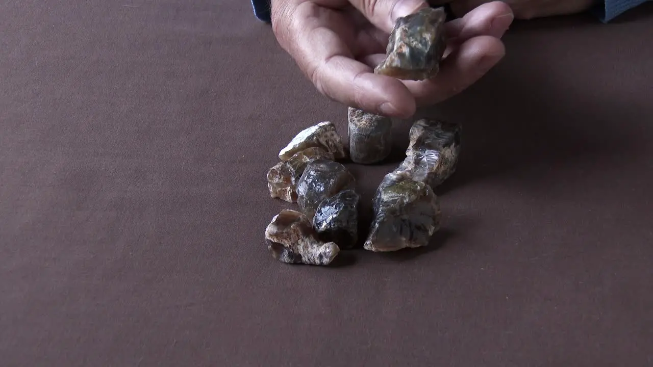 A gemologist inspecting a parcel of rough and rare African Cat's Eye Opal close up