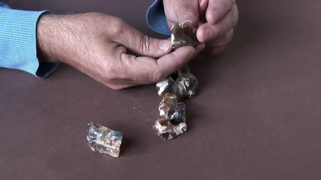 A Gemstone cutter selecting rare African Cat's Eye Opal from a parcel of rough