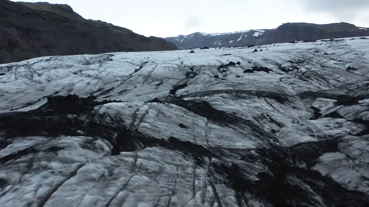 Dark frozen ice at bottom of Sólheimajökull glacier in Iceland aerial