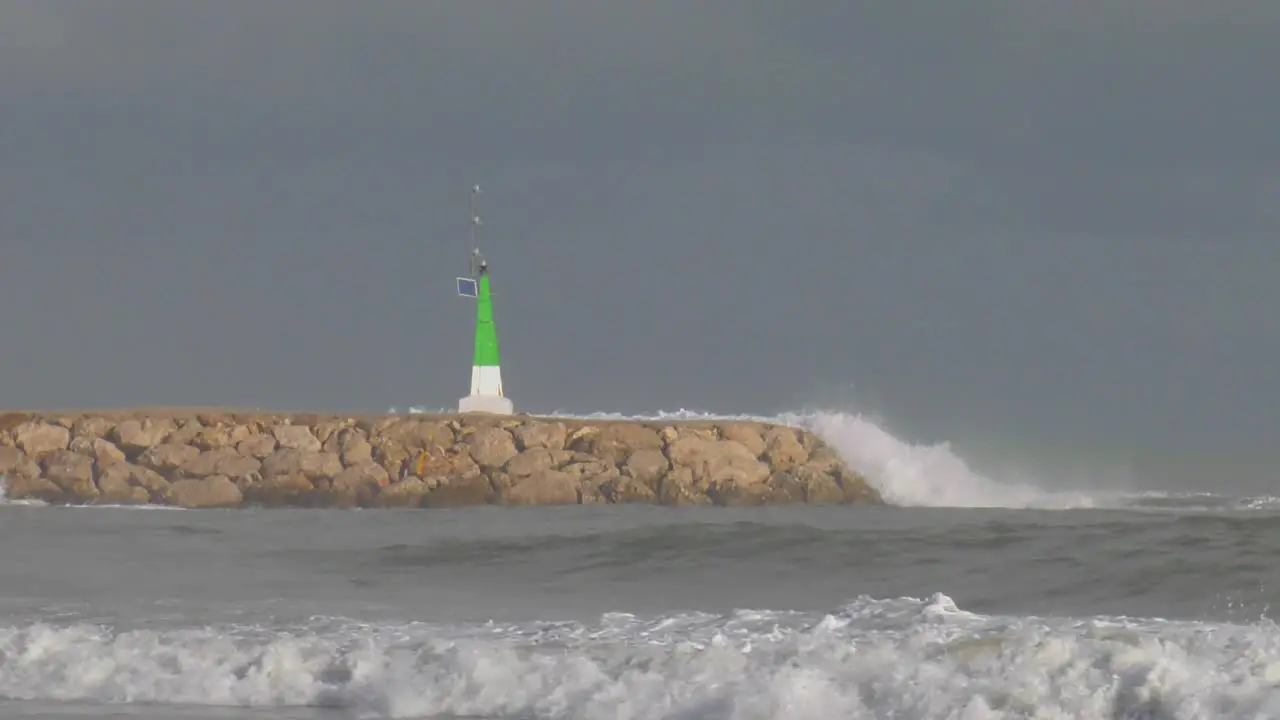 Big waves crashing over sea wall at harbor slow motion