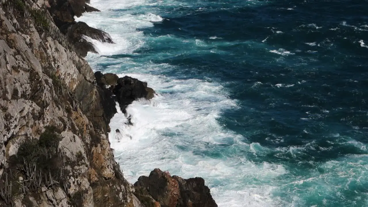 strong waves crash against rock cliffs at high tide slowmotion shot