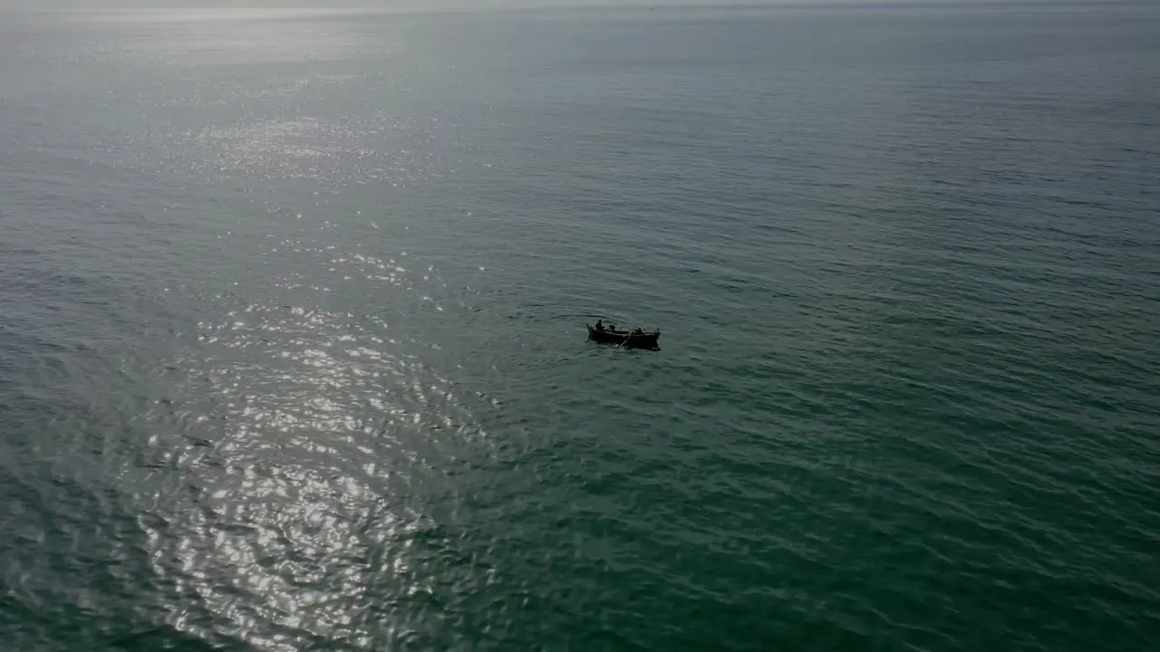 Aerial View Of Silhouette Of Boat Floating In Arabian Sea With Sunlight Reflection