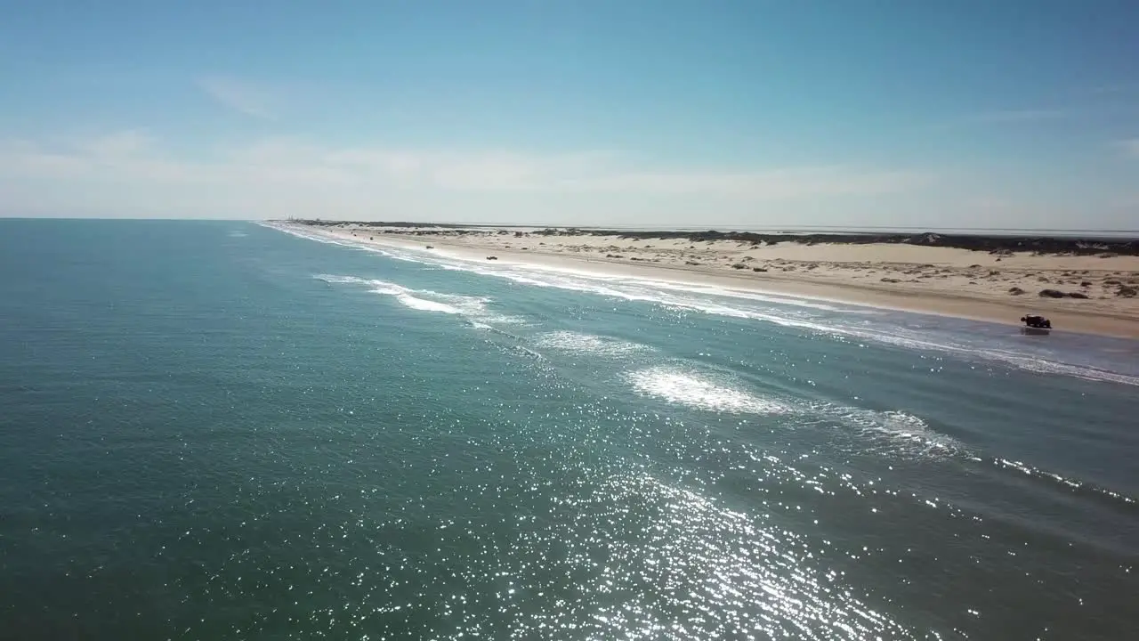 Aerial drone view with increasing elevation of beach and sand dunes at low tide on a gulf coast barrier island on a sunny afternoon South Padre Island Texas