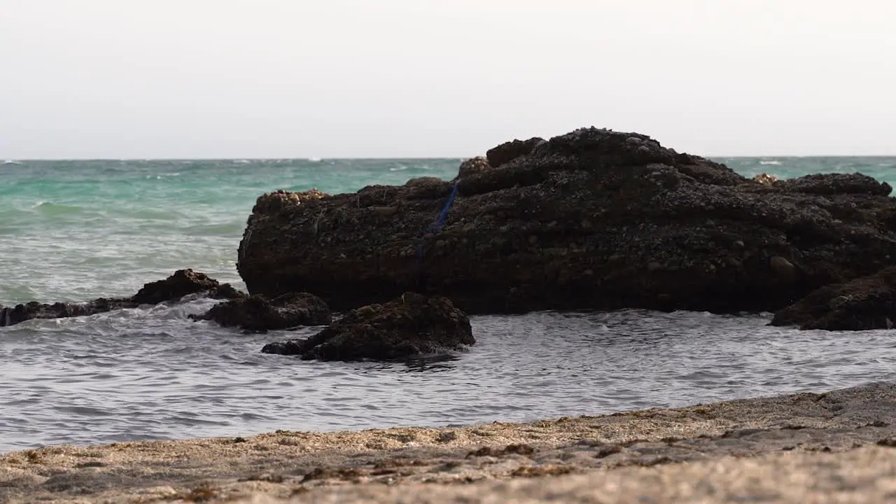 Panning shot over ocean and rocks from beach