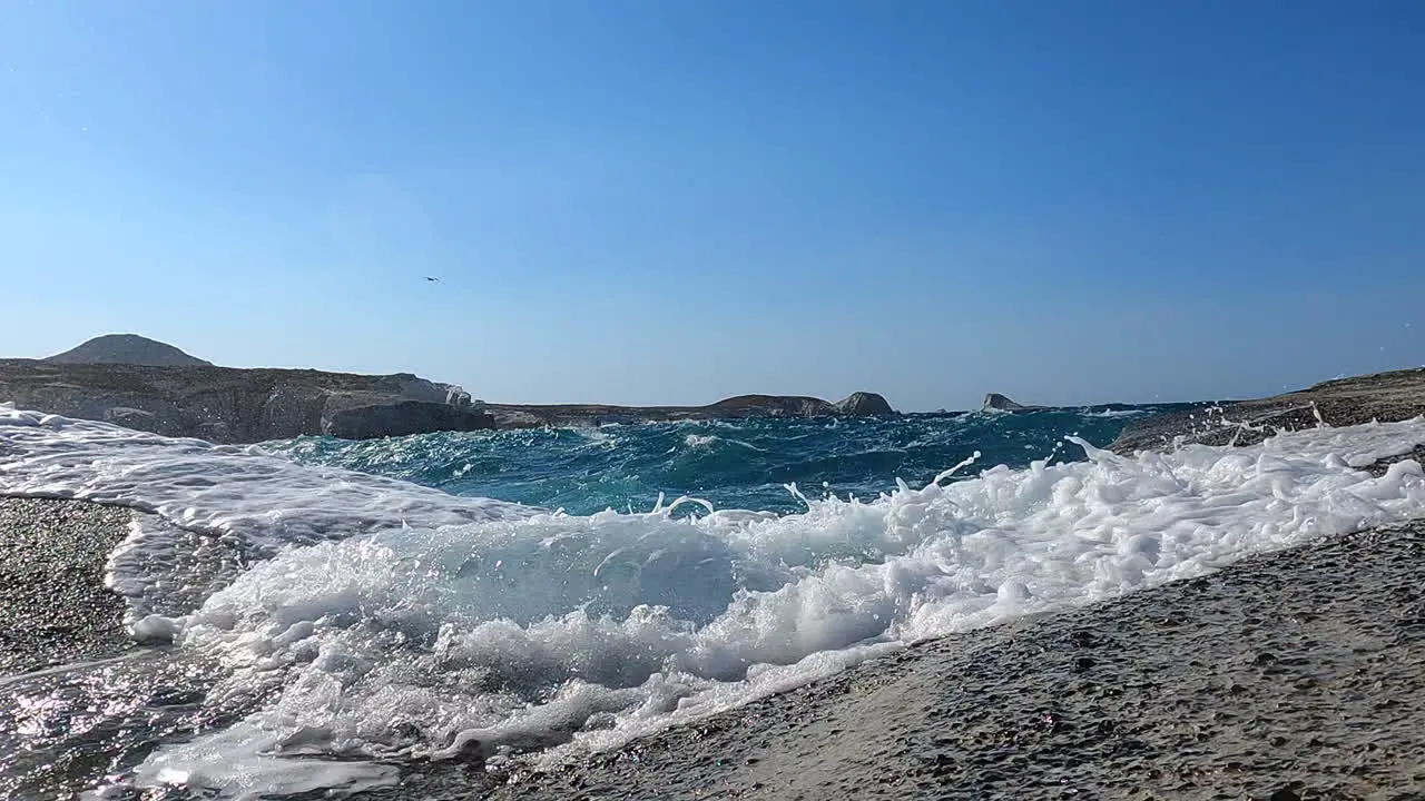 splashing water on a Greek rocky shore windy