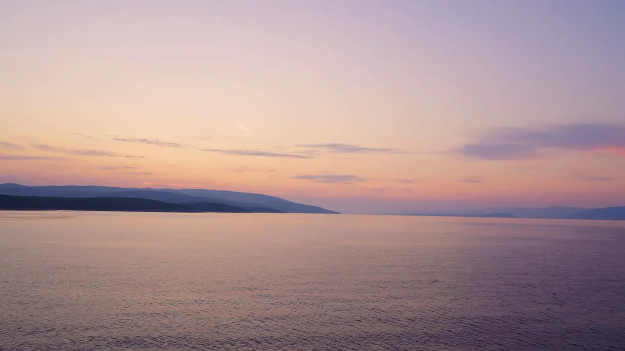 Sunrise sunset over open Adriatic sea with coast visible in the background