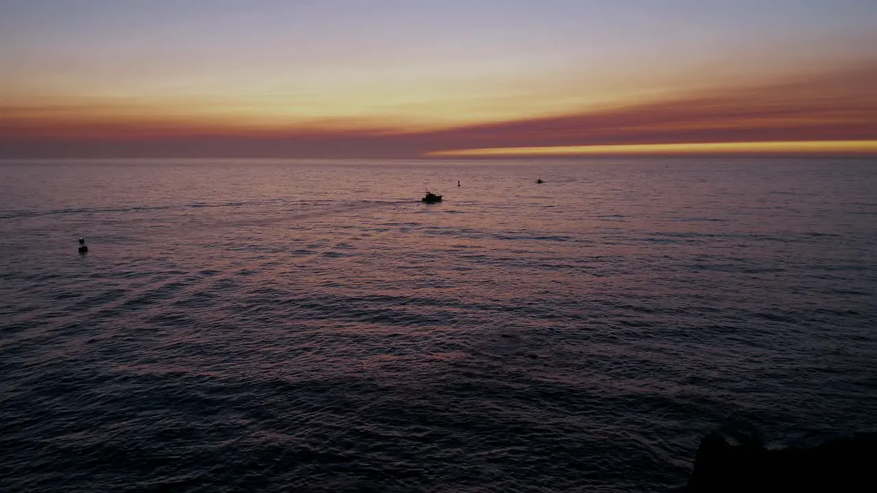 Two silhouetted boats in the ocean at sunset