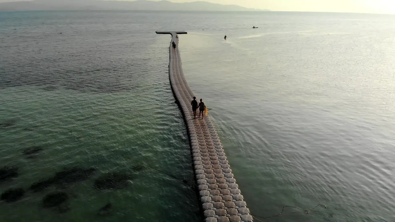 Drone shot of a couple walking on a floating pier