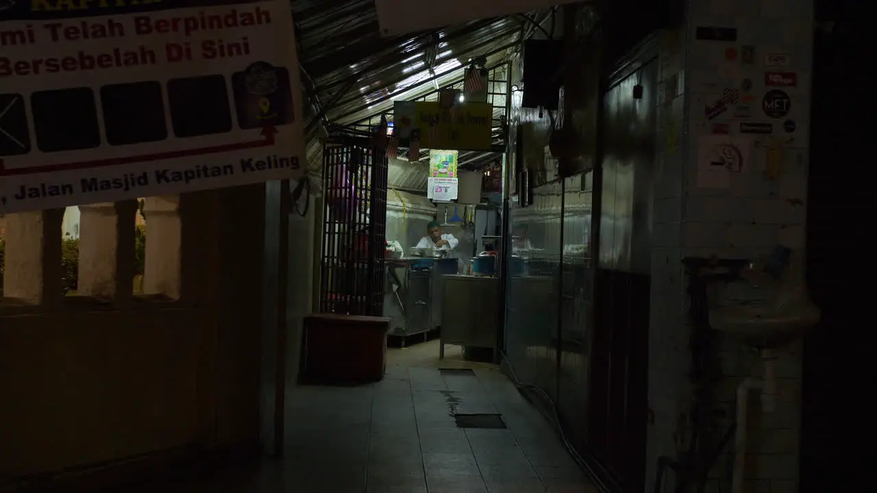 Chef Prepares Food in Small Dimly Lit Restaurant Night Malaysia