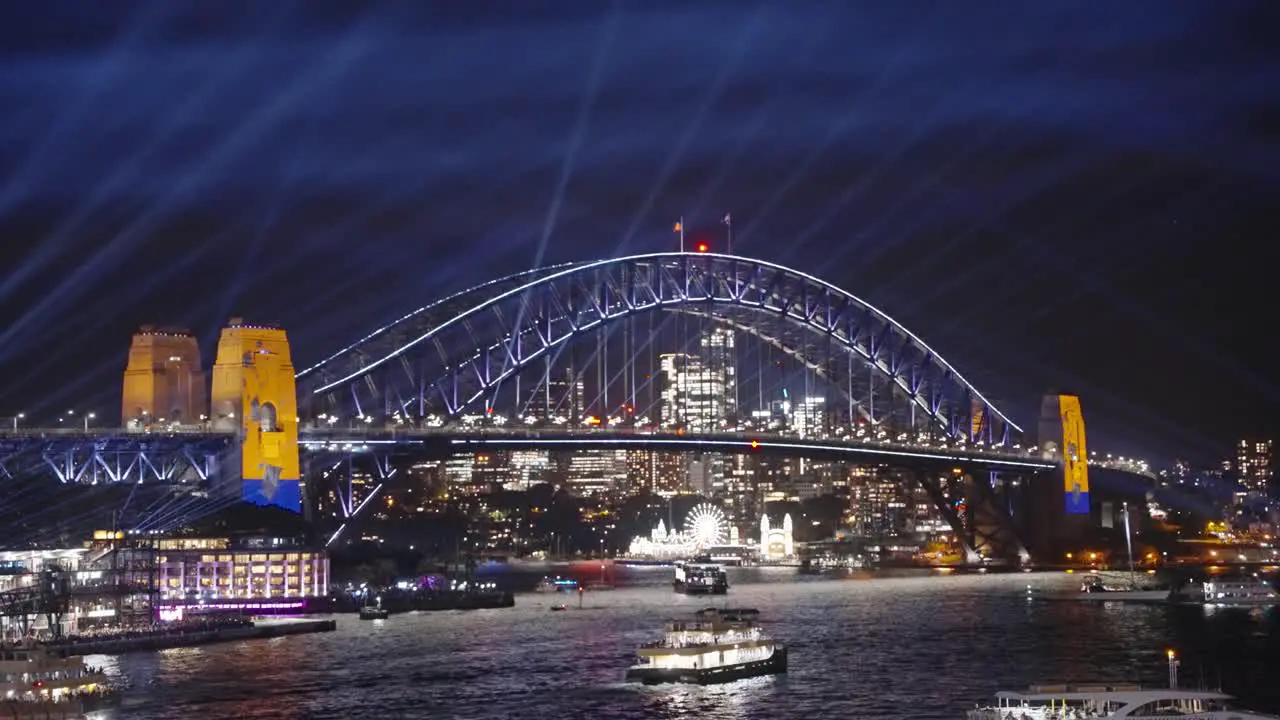 Boats passing the Harbour bridge during Sydney's Vivid light festival