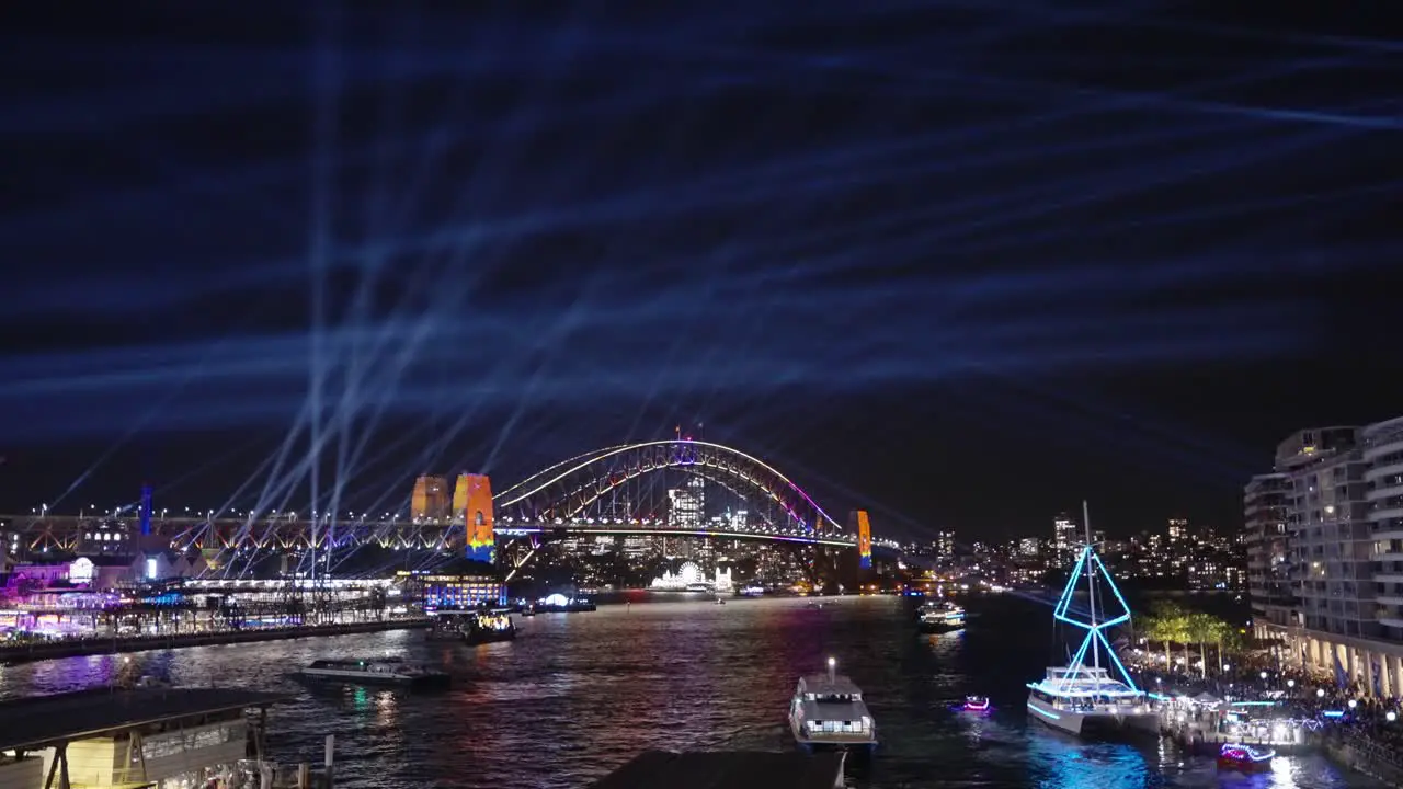 Boats passing the Harbour bridge during Sydney's Vivid light festival Wide Shot