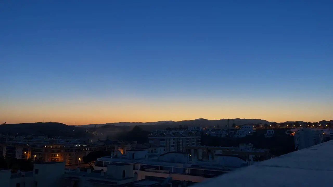 Timelapse from a skyscraper roof on a small town in the evening from evening to night many yellow lights come on near Malaga