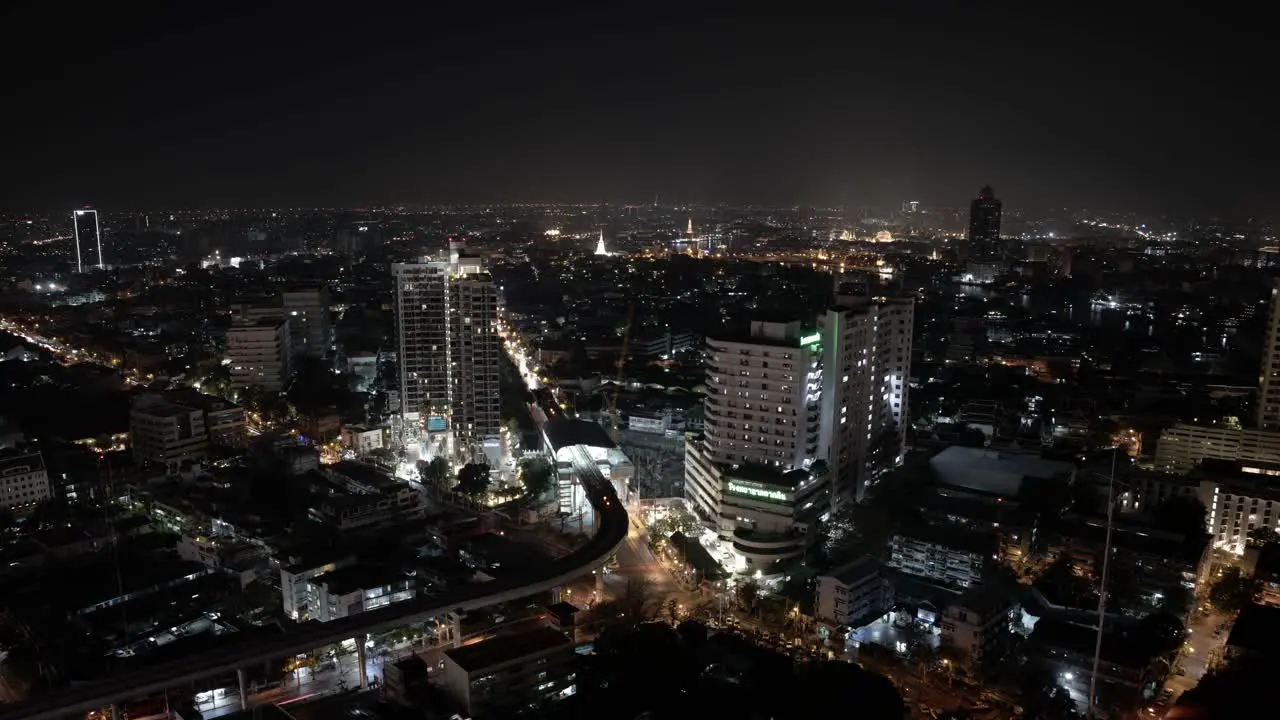 A nighttime time lapse shot of cars passing through a bustling intersection in Bangkok Thailand shot from a skyscraper