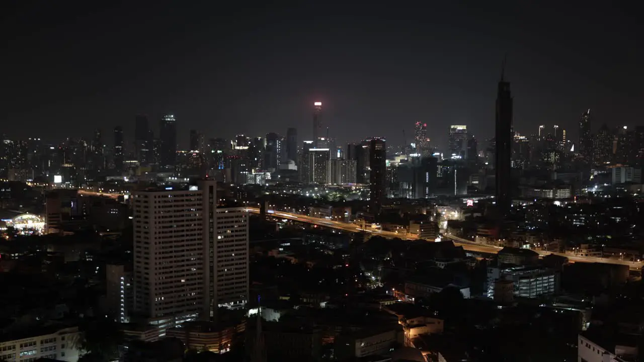 A nighttime time lapse shot of cards driving down a bustling freeway in Bangkok Thailand