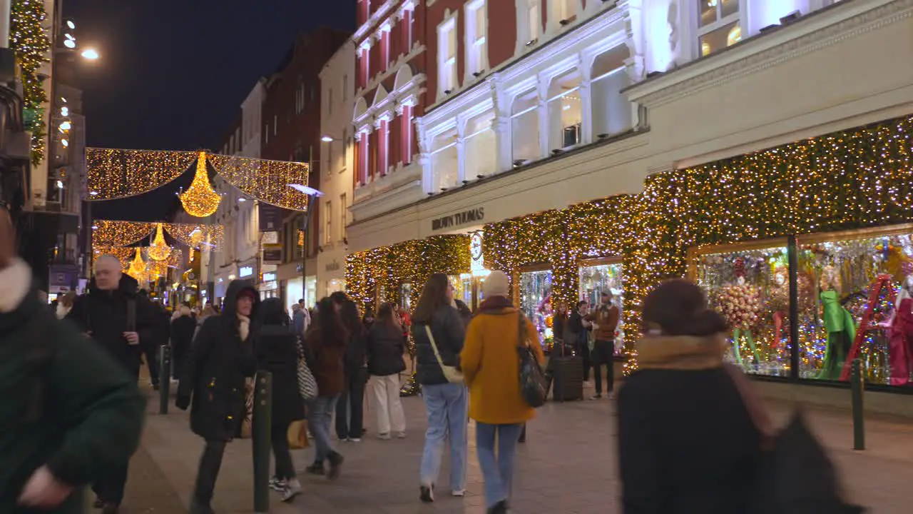 Shopping area with consumers at night with Christmas lights in December Dublin Ireland