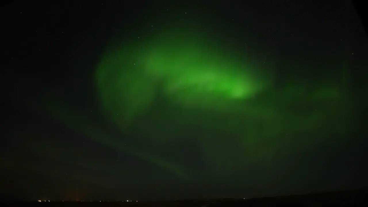 Wide shot of Green Northern Lights at dark sky moving