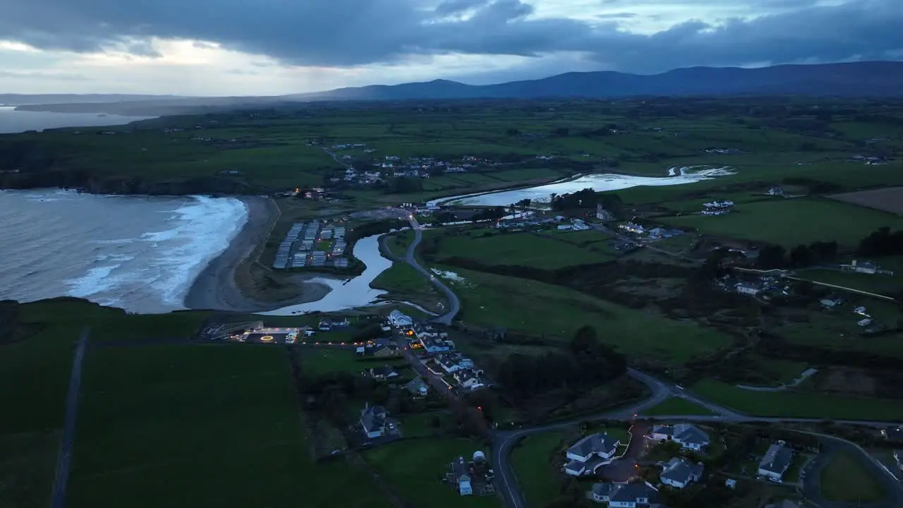 Night drone approach cinematic Bunmahon Village Copper Coast Waterford Ireland on a winter evening with new Coast guard station