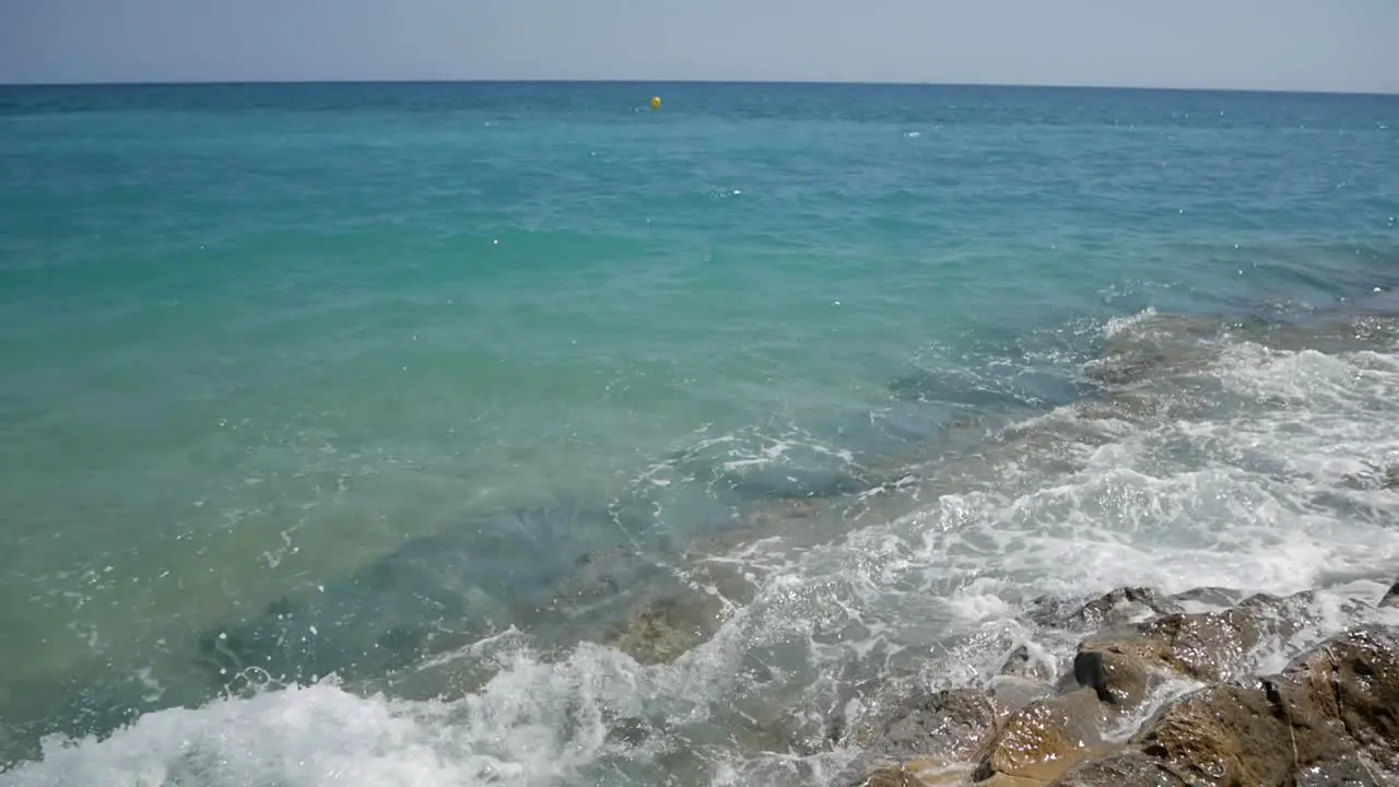 Sea water crashing on rocks by shoreline