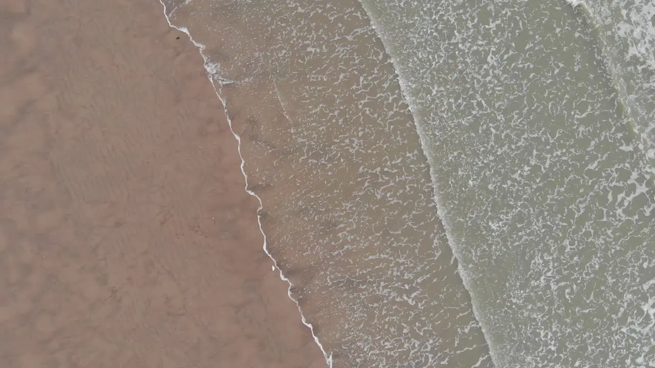 The beach and the sea seen from above with a turning drone