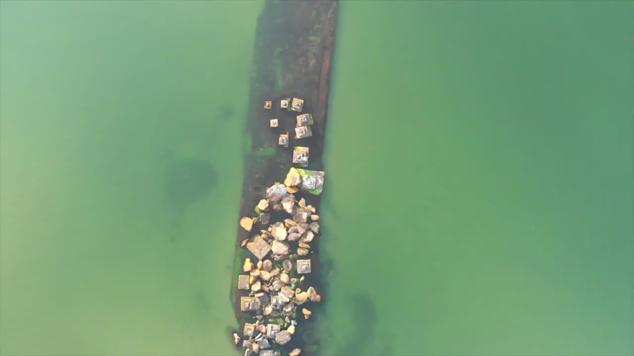 A submerged barge next to the seashore